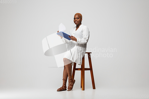 Image of Young african-american woman in casual wear on gray background. Bodypositive female character, plus size businesswoman