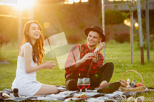 Image of Caucasian young and happy couple enjoying a picnic in the park on summer day