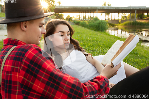 Image of Caucasian young and happy couple enjoying a picnic in the park on summer day