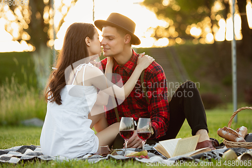 Image of Caucasian young and happy couple enjoying a picnic in the park on summer day