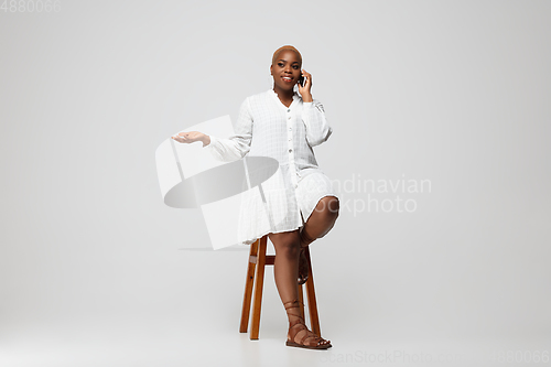 Image of Young african-american woman in casual wear on gray background. Bodypositive female character, plus size businesswoman