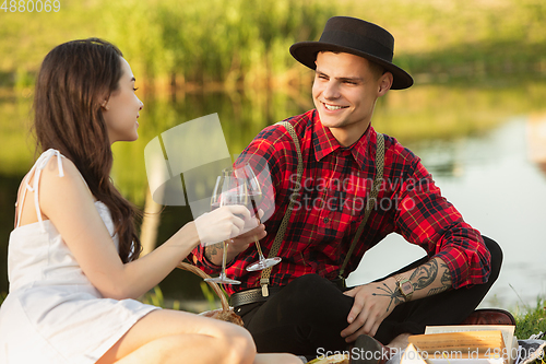 Image of Caucasian young and happy couple enjoying a picnic in the park on summer day