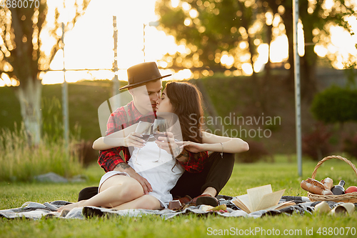 Image of Caucasian young and happy couple enjoying a picnic in the park on summer day