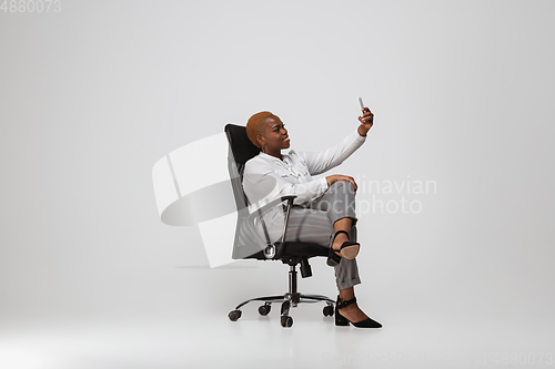 Image of Young african-american woman in office attire on gray background. Bodypositive female character. plus size businesswoman