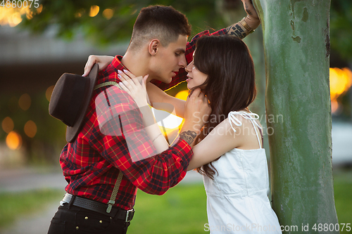 Image of Caucasian young and happy couple enjoying a picnic in the park on summer day