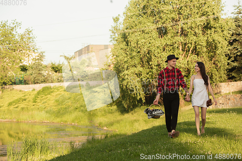 Image of Caucasian young and happy couple enjoying a picnic in the park on summer day