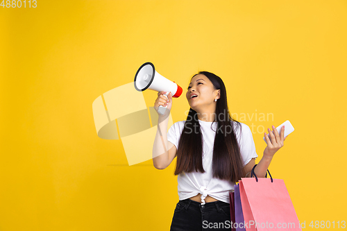 Image of Portrait of young asian woman isolated on yellow studio background