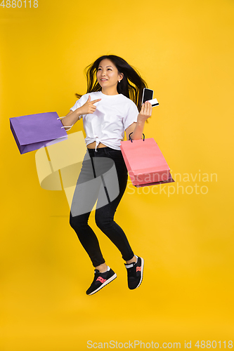 Image of Portrait of young asian woman isolated on yellow studio background