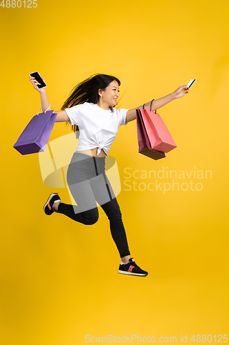 Image of Portrait of young asian woman isolated on yellow studio background