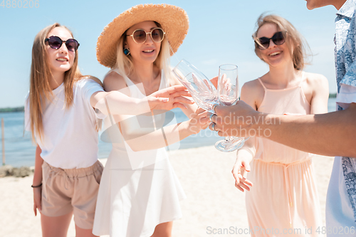 Image of Seasonal feast at beach resort. Group of friends celebrating, resting, having fun on the beach in sunny summer day