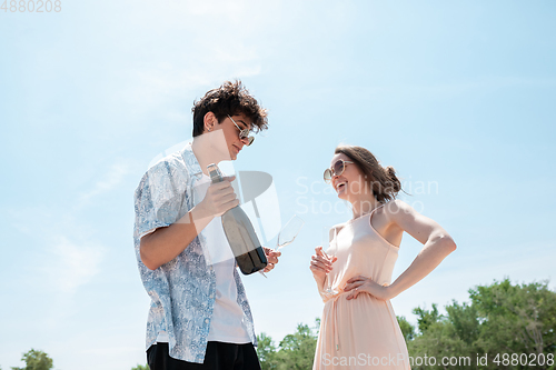 Image of Seasonal feast at beach resort. Happy couple or friends celebrating, resting, having fun on the beach in sunny summer day