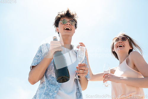 Image of Seasonal feast at beach resort. Happy couple or friends celebrating, resting, having fun on the beach in sunny summer day