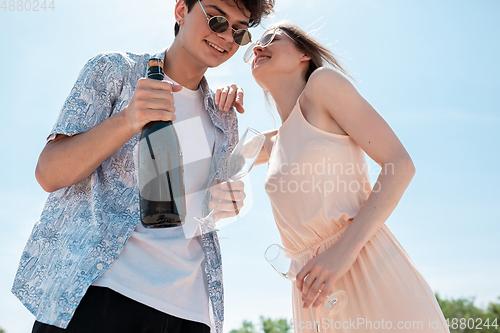 Image of Seasonal feast at beach resort. Happy couple or friends celebrating, resting, having fun on the beach in sunny summer day