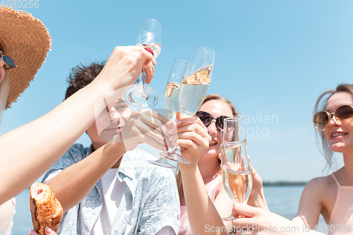 Image of Seasonal feast at beach resort. Group of friends celebrating, resting, having fun on the beach in sunny summer day