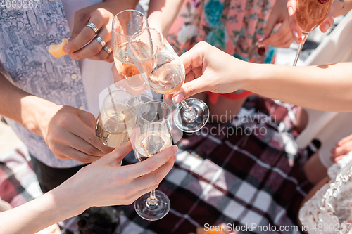 Image of Seasonal feast at beach resort. Group of friends celebrating, resting, having fun on the beach in sunny summer day