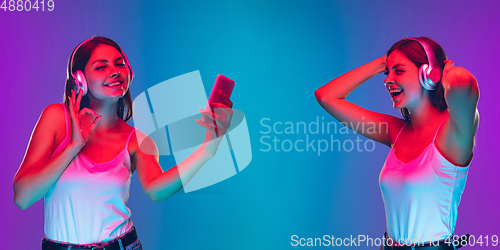 Image of Caucasian young woman\'s portrait isolated on blue background in neon light