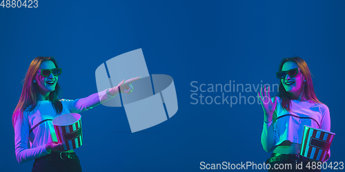 Image of Caucasian young woman\'s portrait on blue background in neon light