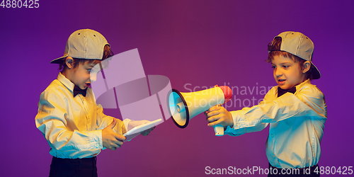Image of Caucasian boy\'s portrait on gradient studio background in neon light. Beautiful curly model. Concept of human emotions, facial expression, sales, ad, tech
