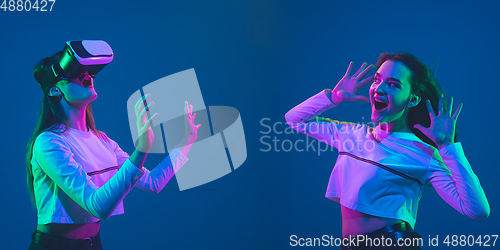Image of Caucasian young woman\'s portrait on blue background in neon light