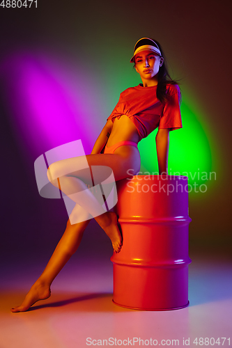 Image of Beautiful seductive girl in fashionable swimsuit on disco bicolored neon studio background in neon light. Summer, resort, fashion and weekend concept