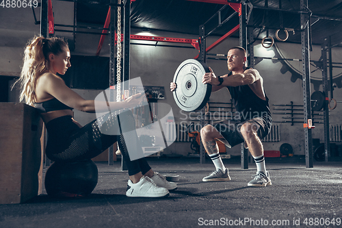 Image of Beautiful young sporty couple training, workout in gym together