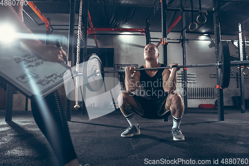 Image of Beautiful young sporty couple training, workout in gym together