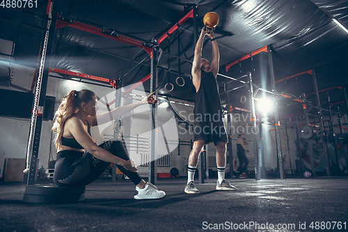 Image of Beautiful young sporty couple training, workout in gym together