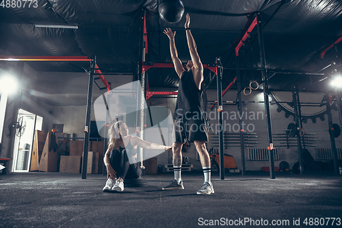 Image of Beautiful young sporty couple training, workout in gym together