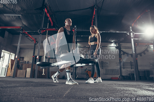 Image of Beautiful young sporty couple training, workout in gym together