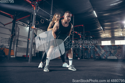 Image of Beautiful young sporty couple training, workout in gym together