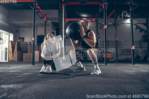 Image of Beautiful young sporty couple training, workout in gym together