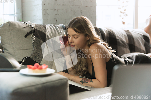 Image of Portrait of pretty young girl in modern apartment in the morning. Resting, calm, salisfied. Youth and wellness concept.