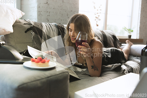 Image of Portrait of pretty young girl in modern apartment in the morning. Resting, calm, salisfied. Youth and wellness concept.