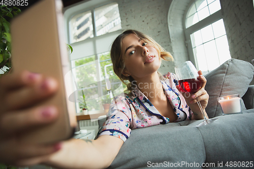 Image of Portrait of pretty young girl in modern apartment in the morning. Resting, calm, salisfied. Youth and wellness concept.