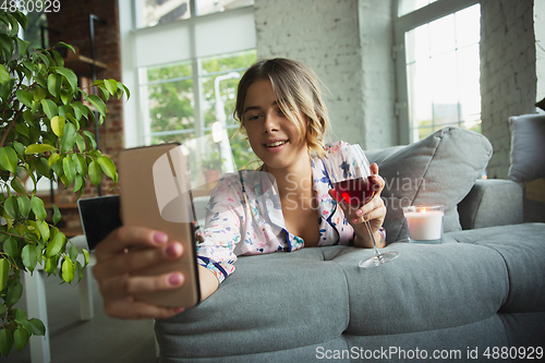 Image of Portrait of pretty young girl in modern apartment in the morning. Resting, calm, salisfied. Youth and wellness concept.