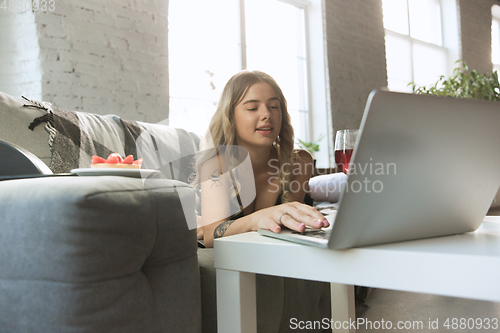 Image of Portrait of pretty young girl in modern apartment in the morning. Resting, calm, salisfied. Youth and wellness concept.