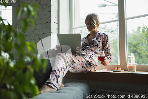 Image of Portrait of pretty young girl in modern apartment in the morning. Resting, calm, salisfied. Youth and wellness concept.