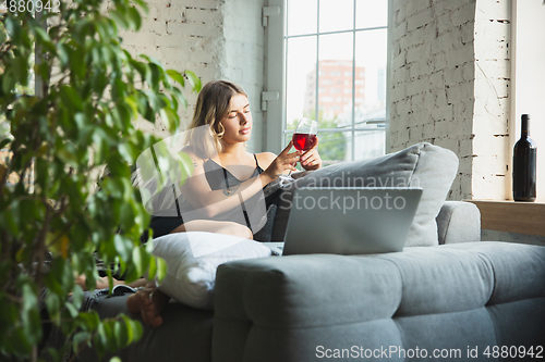 Image of Portrait of pretty young girl in modern apartment in the morning. Resting, calm, salisfied. Youth and wellness concept.