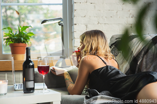 Image of Portrait of pretty young girl in modern apartment in the morning. Resting, calm, salisfied. Youth and wellness concept.