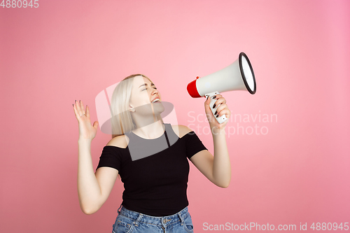 Image of Portrait of young caucasian woman with bright emotions on coral pink studio background