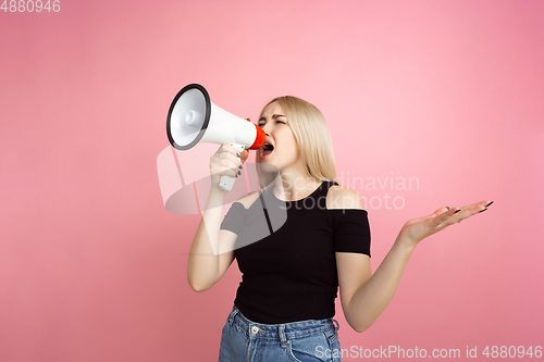 Image of Portrait of young caucasian woman with bright emotions on coral pink studio background