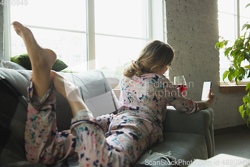 Image of Portrait of pretty young girl in modern apartment in the morning. Resting, calm, salisfied. Youth and wellness concept.