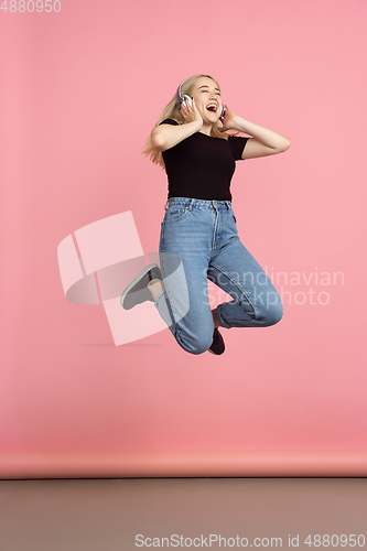 Image of Portrait of young caucasian woman with bright emotions on coral pink studio background