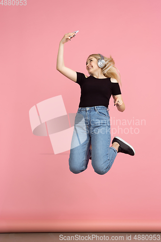 Image of Portrait of young caucasian woman with bright emotions on coral pink studio background