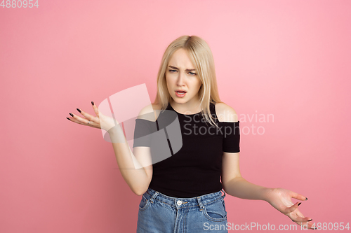 Image of Portrait of young caucasian woman with bright emotions on coral pink studio background