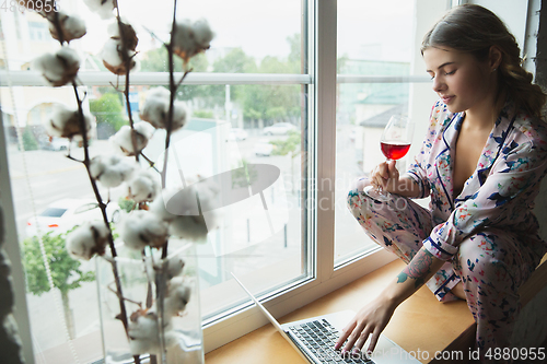 Image of Portrait of pretty young girl in modern apartment in the morning. Resting, calm, salisfied. Youth and wellness concept.