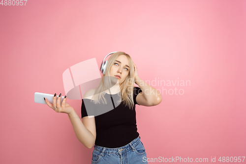 Image of Portrait of young caucasian woman with bright emotions on coral pink studio background