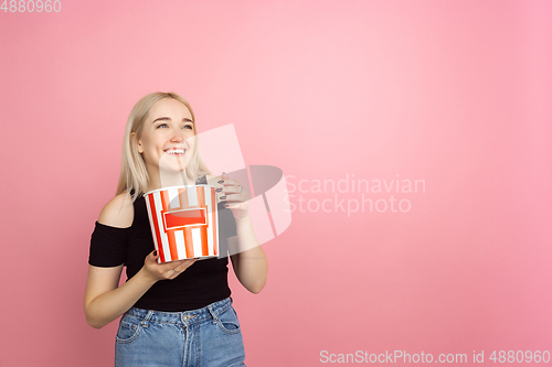 Image of Portrait of young caucasian woman with bright emotions on coral pink studio background