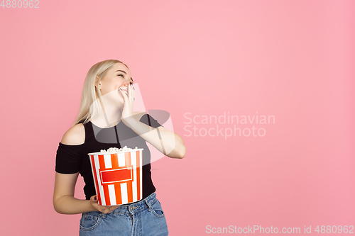 Image of Portrait of young caucasian woman with bright emotions on coral pink studio background