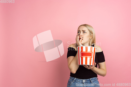 Image of Portrait of young caucasian woman with bright emotions on coral pink studio background